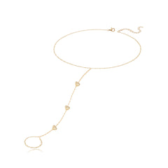 Dripping scattered gemstone hearts hand chain in 14k gold, playful and elegant luxury design.